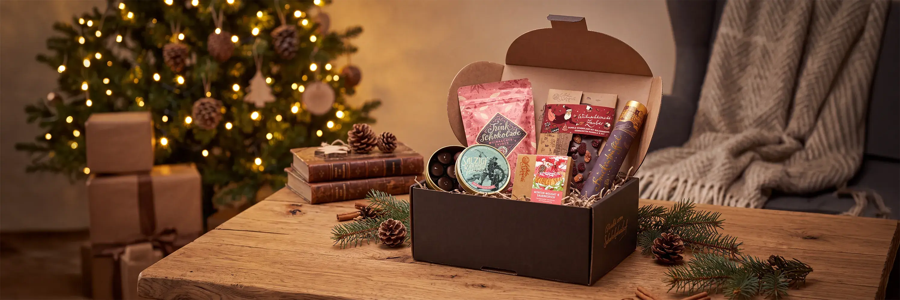 Weihnachtspäckchen mit verschiedenen Schokoladen steht auf einem weihnachtlich geschmückten Tisch.