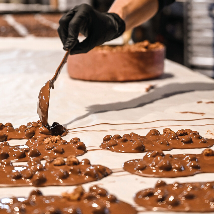 Goldhelm Tafelschokolade wird auf der Arbeitsplatte ausgestrichen und veredelt.